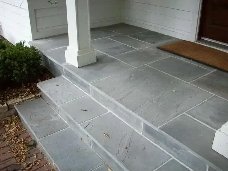 Freshly sealed gray stone steps elevate the entrance to a home.