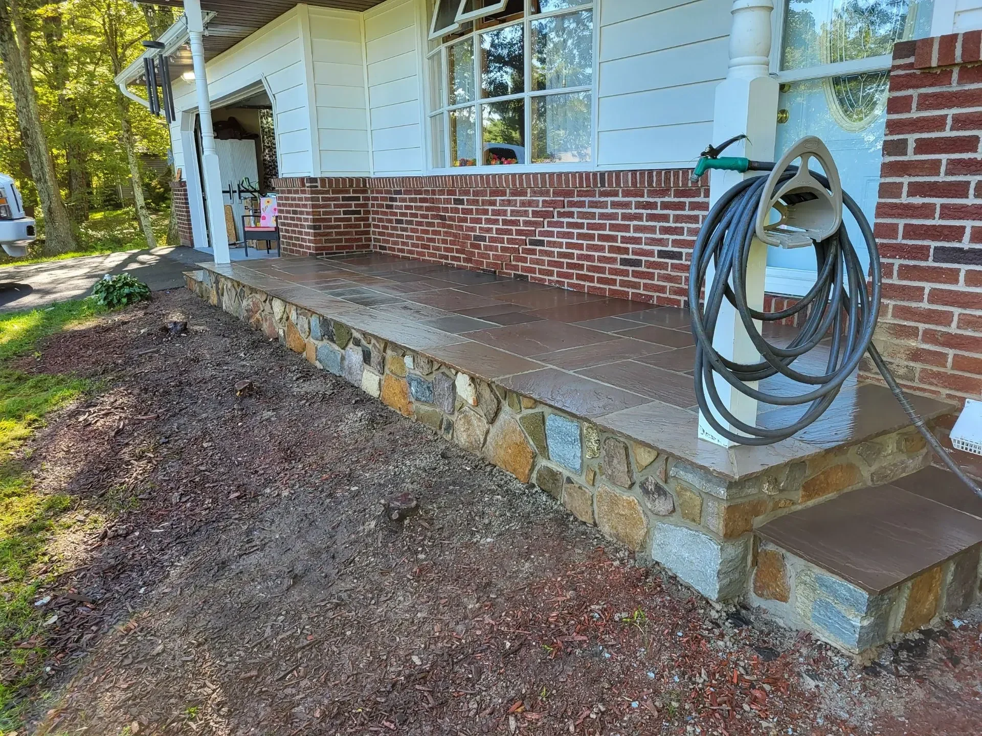 Clean slate tiles meet multicolored stone veneer along a refreshed porch.
